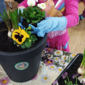 Dziewczynka sadzi kwiatki.