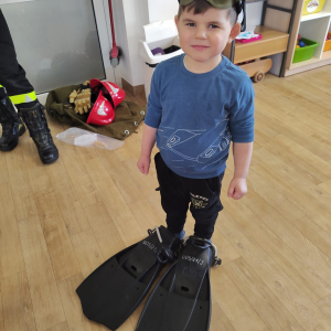 Dziecko przymierza strój strażaka do nurkowania.