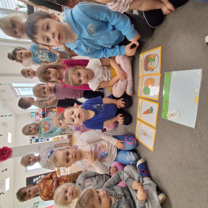 dzieci siedzą i razem z piosenką liczą króliczki