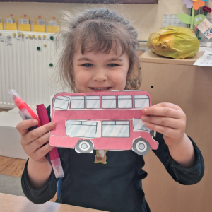 dziecko trzyma czerwony autobus