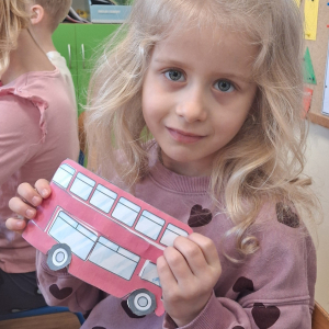 dziecko trzyma czerwony autobus