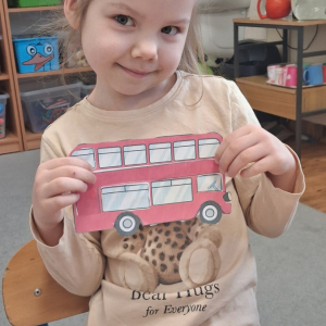 dziecko trzyma czerwony autobus