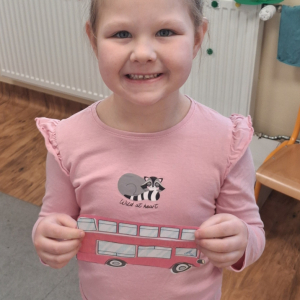 dziecko trzyma czerwony autobus