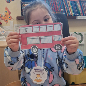 dziecko trzyma czerwony autobus
