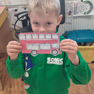 dziecko trzyma czerwony autobus