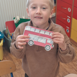 dziecko trzyma czerwony autobus