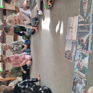 Dzieci siedzą na dywanie poznają środki transportu