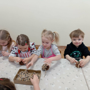 dzieci przygotowujące kule z ziarnami dla ptaków