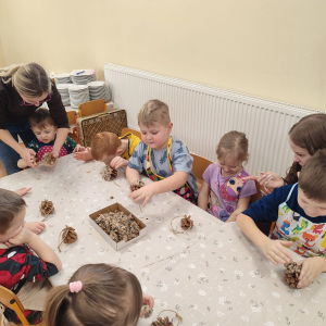 dzieci przygotowujące kule z ziarnami dla ptaków
