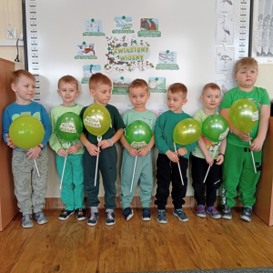 chłopcy trzymający zielone baloniki