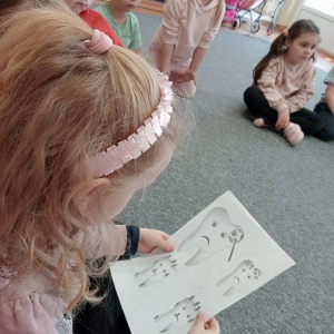 dzieci oglądające ilustracje przedstawiające dbanie o zęby