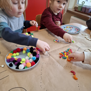 Dzieci układają przedmioty na szablonie