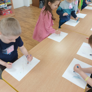 Dzieci kreślą kreski i kropki do muzyki
