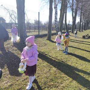 Dzieci szukające koszyczków wielkanocnych w ogrodzie