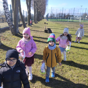 Dzieci szukające koszyczków wielkanocnych w ogrodzie
