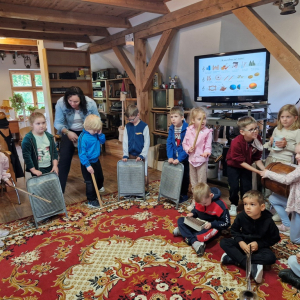 Dzieci trzymają kaszubskie instrumenty muzyczne, tworząc orkiestrę