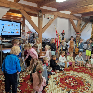Dzieci grają na  ludowych instrumentach muzycznych