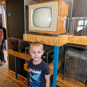 Chłopiec na tle starego telewizora lampowego